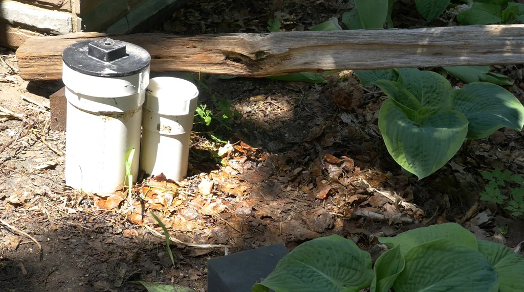Exterior sewer cleanout access pipes beside a Toronto home